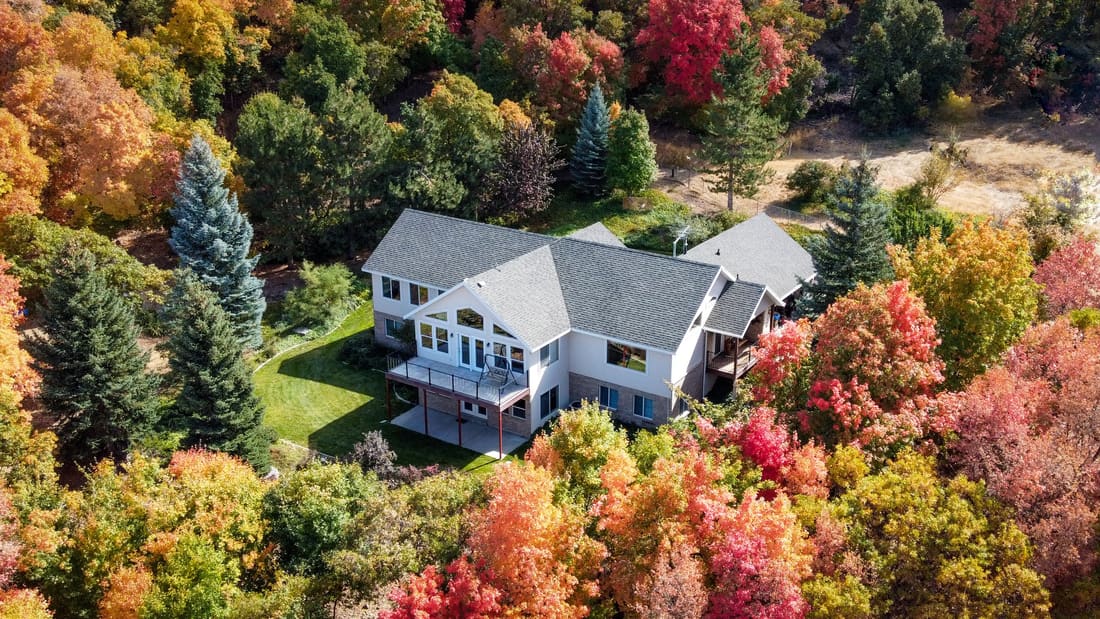 Aerial drone view of a large house surrounded by an autumn forest, in the Québec City area